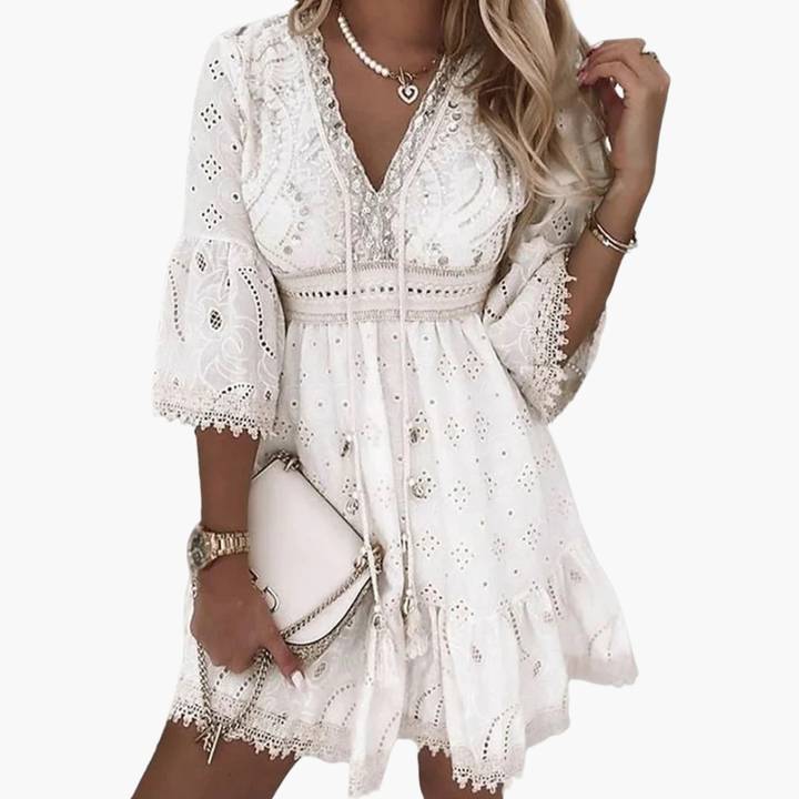 Elegant beige damklänning med V-ringning och utsvängda ärmar, perfekt som sommar- eller festklänning.