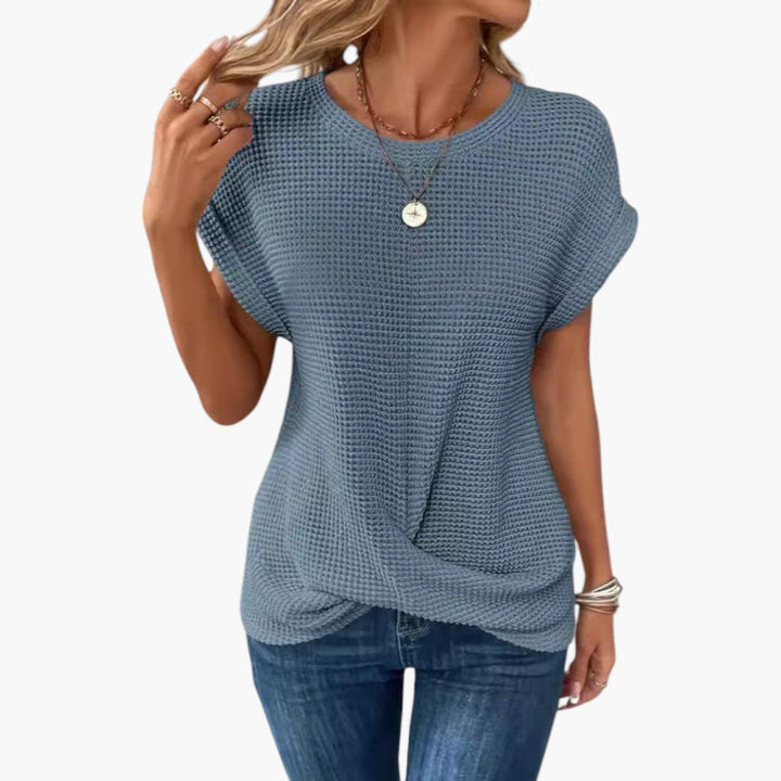 Vit dam T-shirt med båtringning och chic twist. En bekväm kortärmad topp perfekt för sommarens vardagsstil.