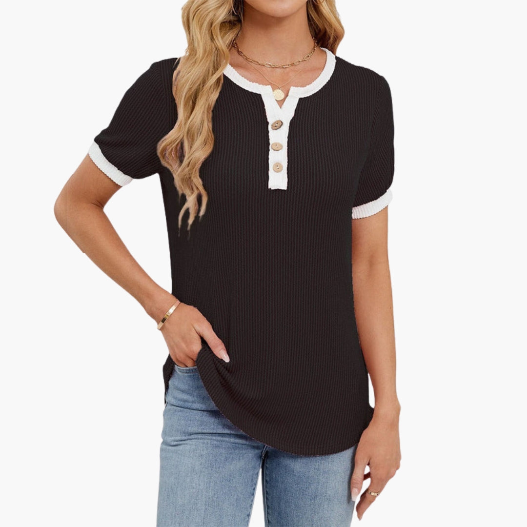 Kortärmad damtopp med unik notch-ringning och dekorativa knappar. En elegant och bekväm vardags-T-shirt.