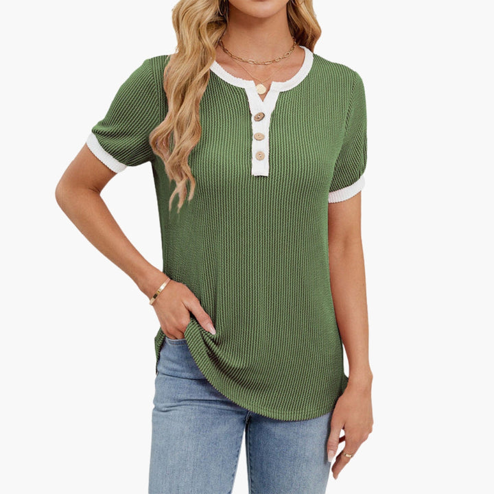 Detaljrik dam T-shirt med elegant notch-ringning och knappar. Kortärmad, bekväm och stilren vardagstopp.