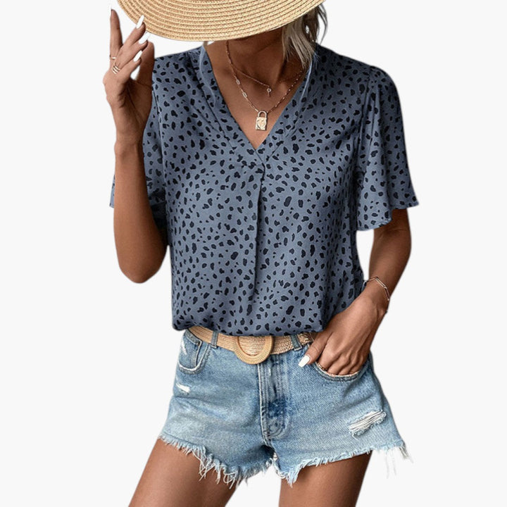 Vacker blus med V-ringning och mönstrat tryck, kort ärm. En elegant och modern sommarblus för dam.