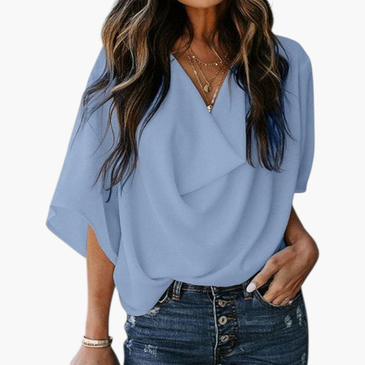 Modern damblus med V-ringning och kort ärm, perfekt för sommar, vardag och eleganta tillfällen.
