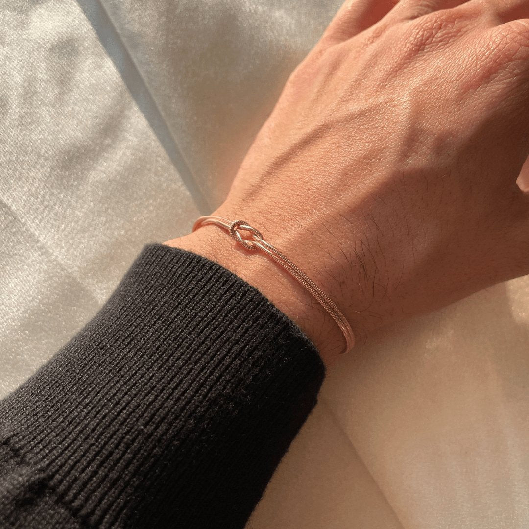 Elegant damarmband med kärleksknop visat på handled som presenttips