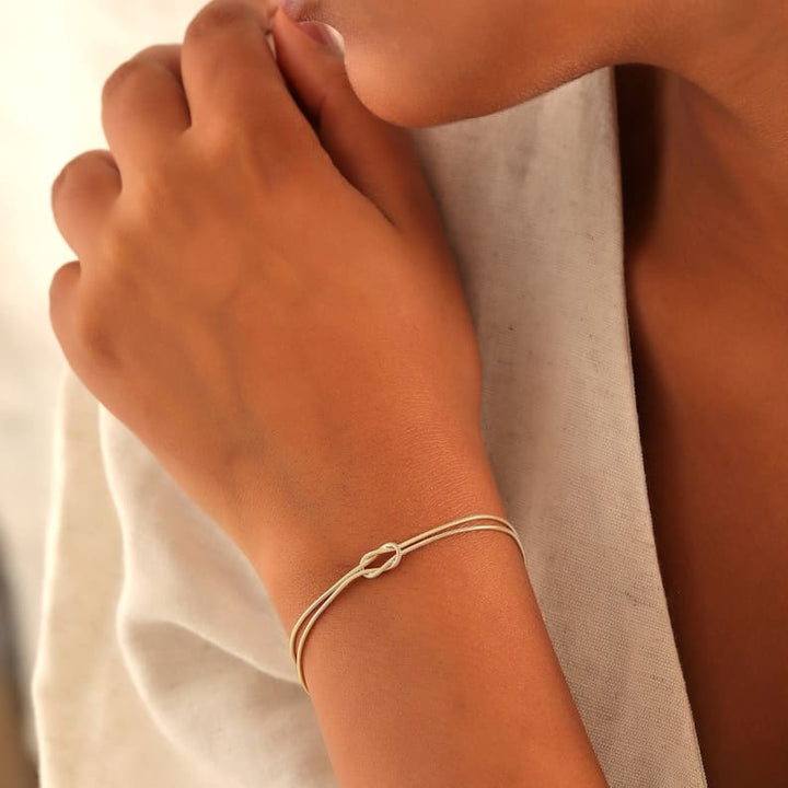Modebild på damarmband med kärleksknop matchat med klocka