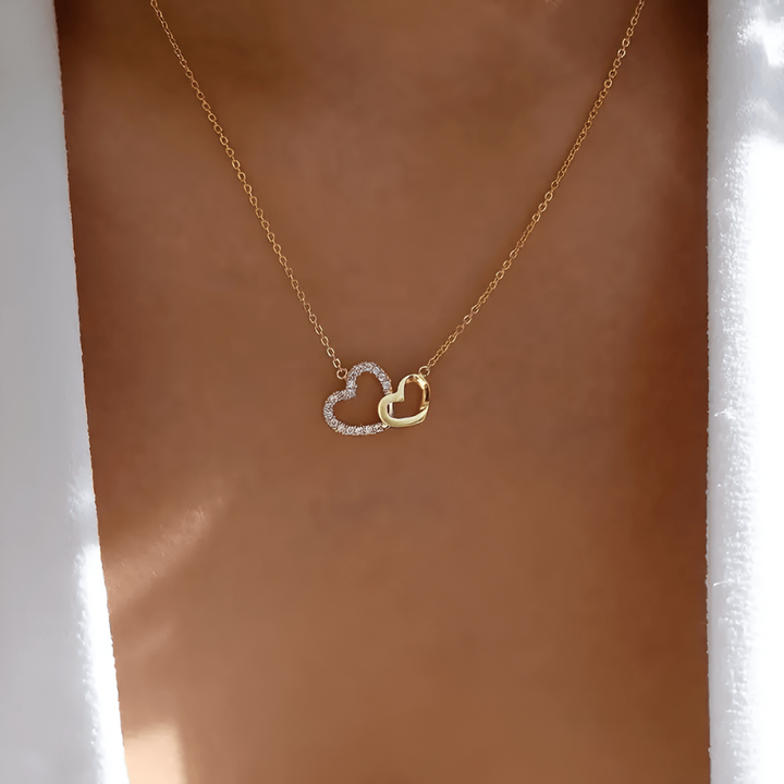 Vackert kvinnorsmycke, Celestina damhalsband, med hjärtformad evighetssymbol i glänsande silver och guld.