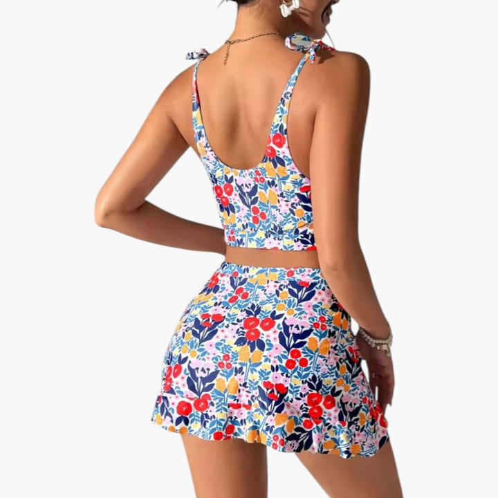 Kvinnligt damset med elegant blommönstrad croppad topp och fladdrande volangkjol för en snygg sommarlook.