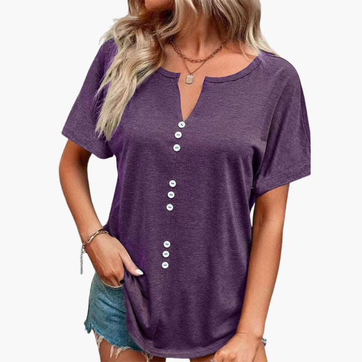 Stilfull damtopp med notch-ringning, knappar och kort ärm. Perfekt för casual och elegant sommarstil.