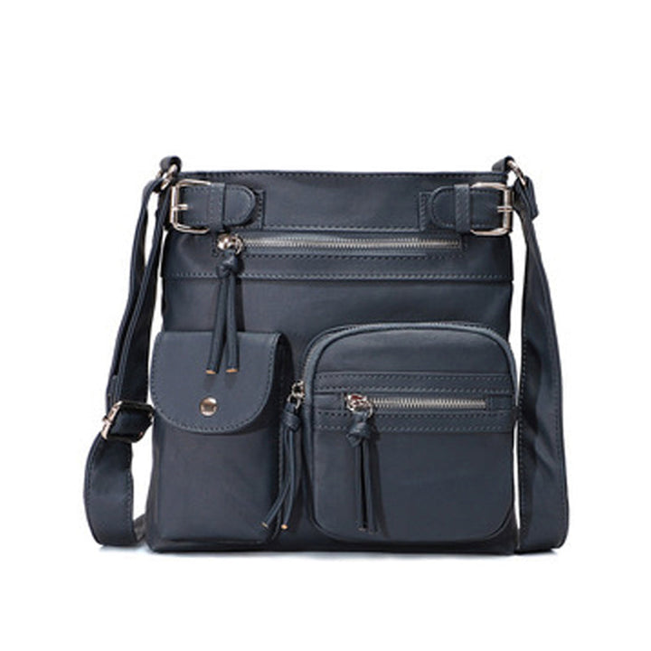 "Elegant damväska i veganskt läder, crossbody med flera fickor, vattentät och stilfull design för optimal organisation."