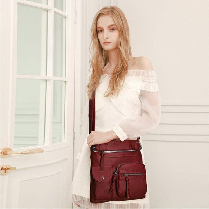 "Elegant damväska i veganskt läder, crossbody med flera fickor, vattentät och stilfull design för optimal organisation."