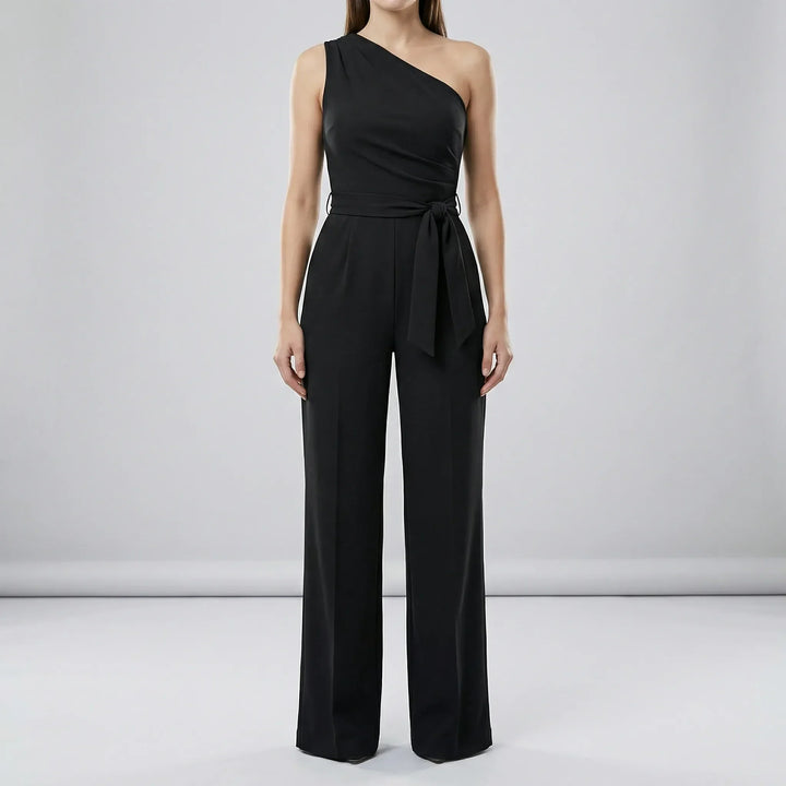Detaljbild av Phoebe damjumpsuitens enaxlade design och knytbälte. Elegant och bekväm stil för varje tillfälle.