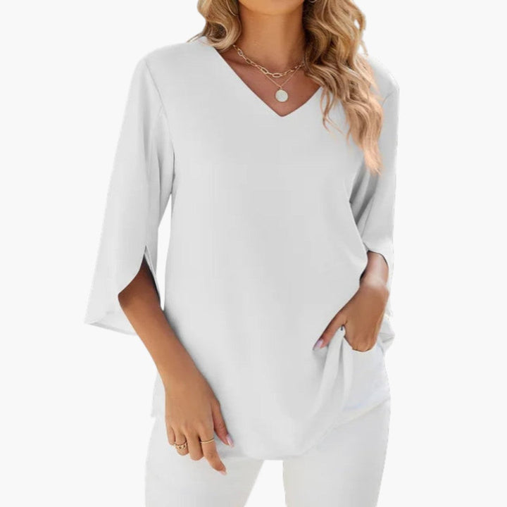 Vardagsmode: Kvinnors v-ringade blus med trekvartsärmar och ärmdetaljer, stylad för en ledig men elegant look.
