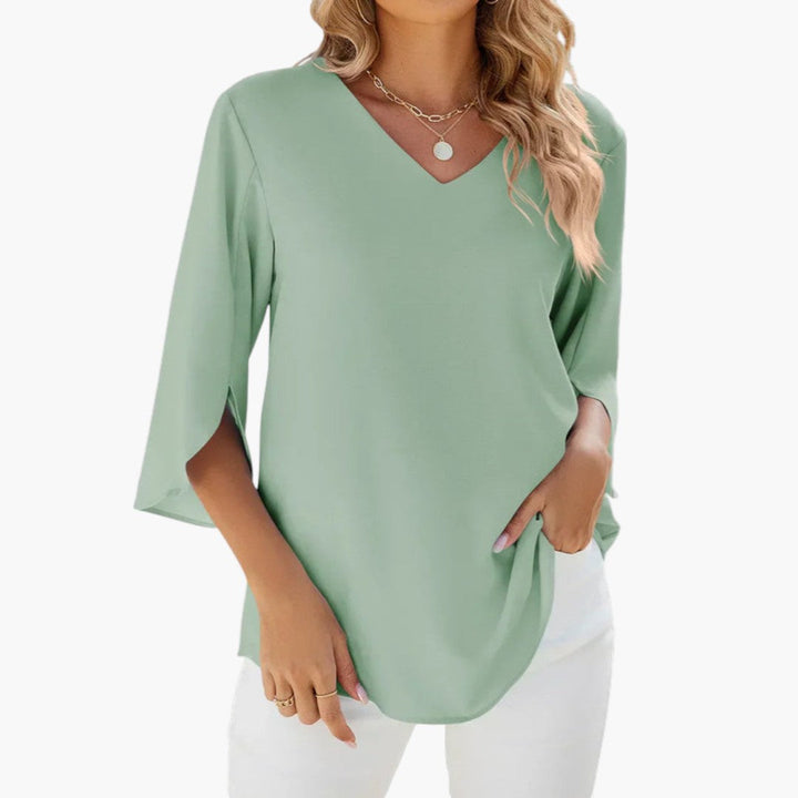 Chic v-ringad blus för kvinnor med feminina trekvartsärmar och sprund, enfärgad design för en elegant vår- och sommarlook.