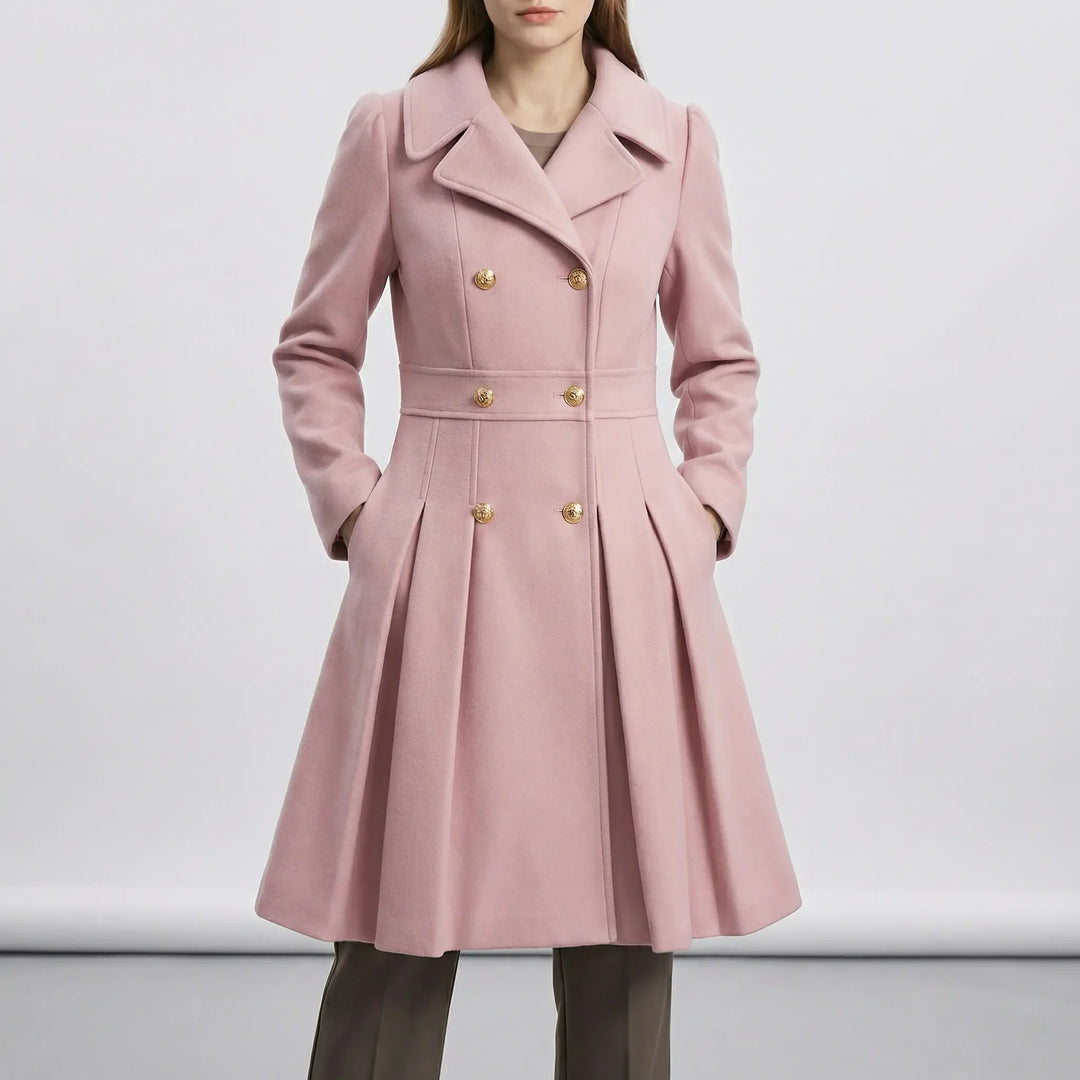 Leah kort kappa i beige, plattlagd. Visar A-linjeformen och dubbelknäppningen på detta eleganta damytterplagg.