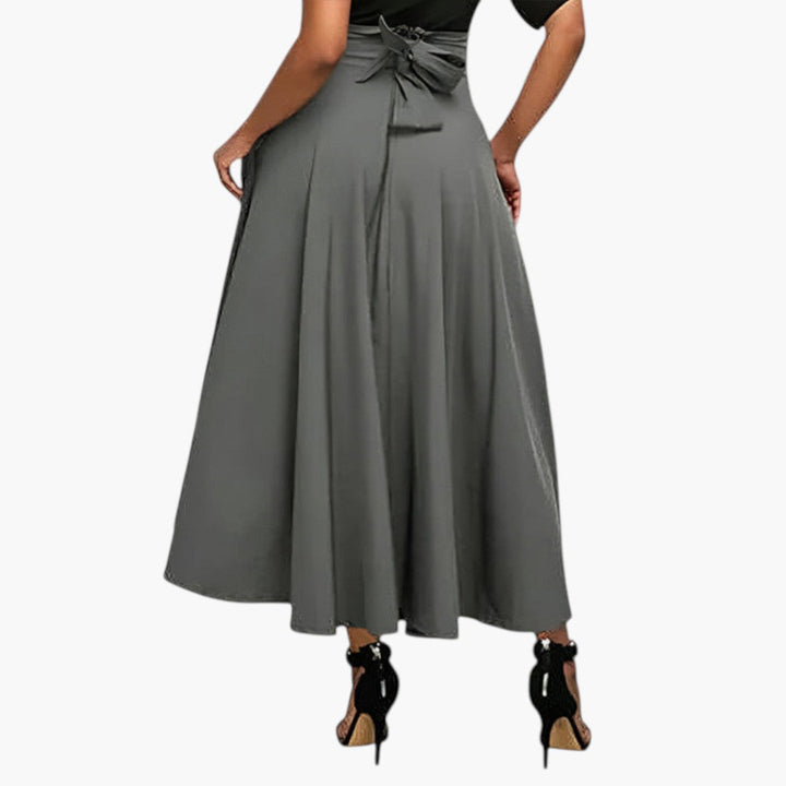 Dam maxikjol, högmidjad och utställd med elegant fall och dolda fickor. Mode för alla tillfällen.