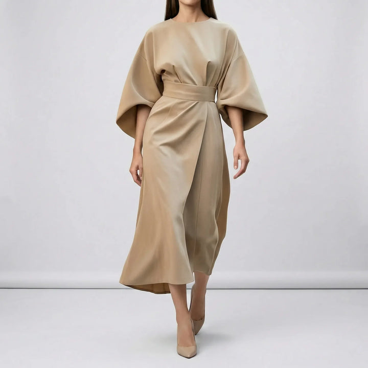 Stilren jadegrön damklänning med midjebälte och lyktärmar. Idealisk festklänning för elegant kvällsoutfit.