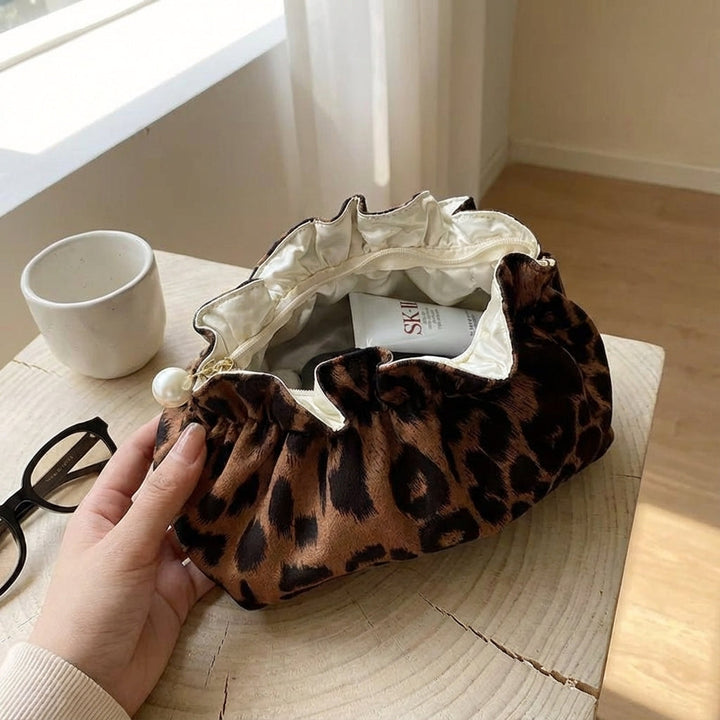Elegant kvinnors ruffle necessär i leopardmönster med pärldetalj. Perfekt sminkväska för smidig förvaring.