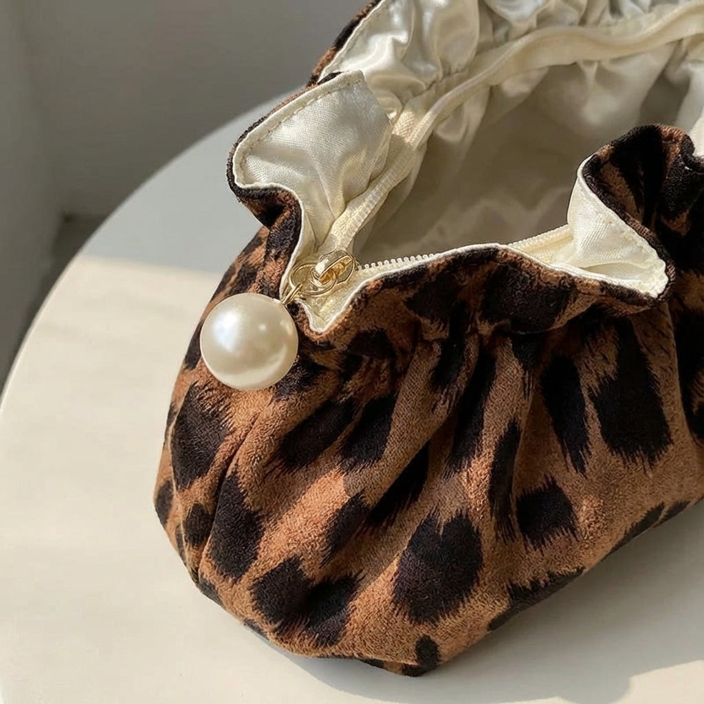 Chic leopardmönstrad sminkväska med ruffle-topp & pärlor. Stilfull organiserare för kvinnors skönhetsprodukter.