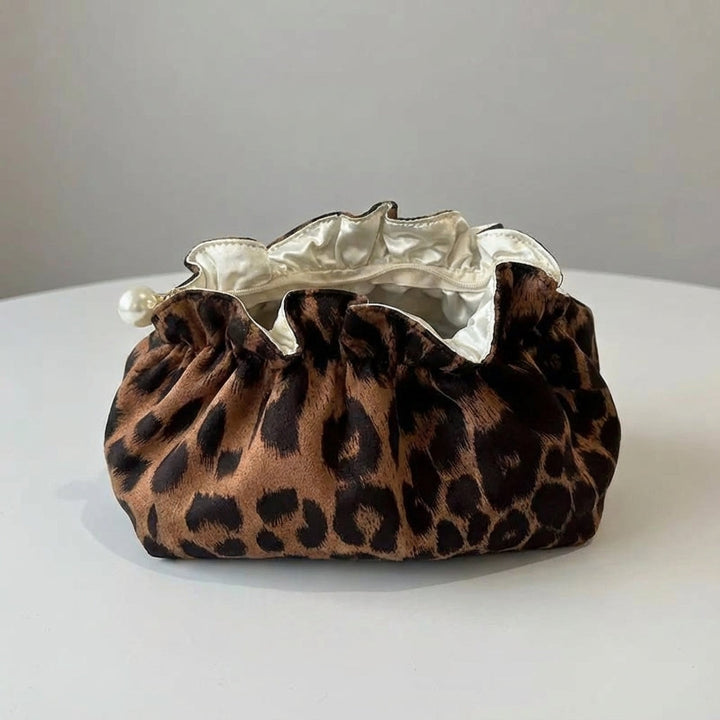 Trendig kvinnors kosmetikväska med ruffle-kant, pärldetaljer & unikt leopardmönster. Praktisk sminkförvaring.