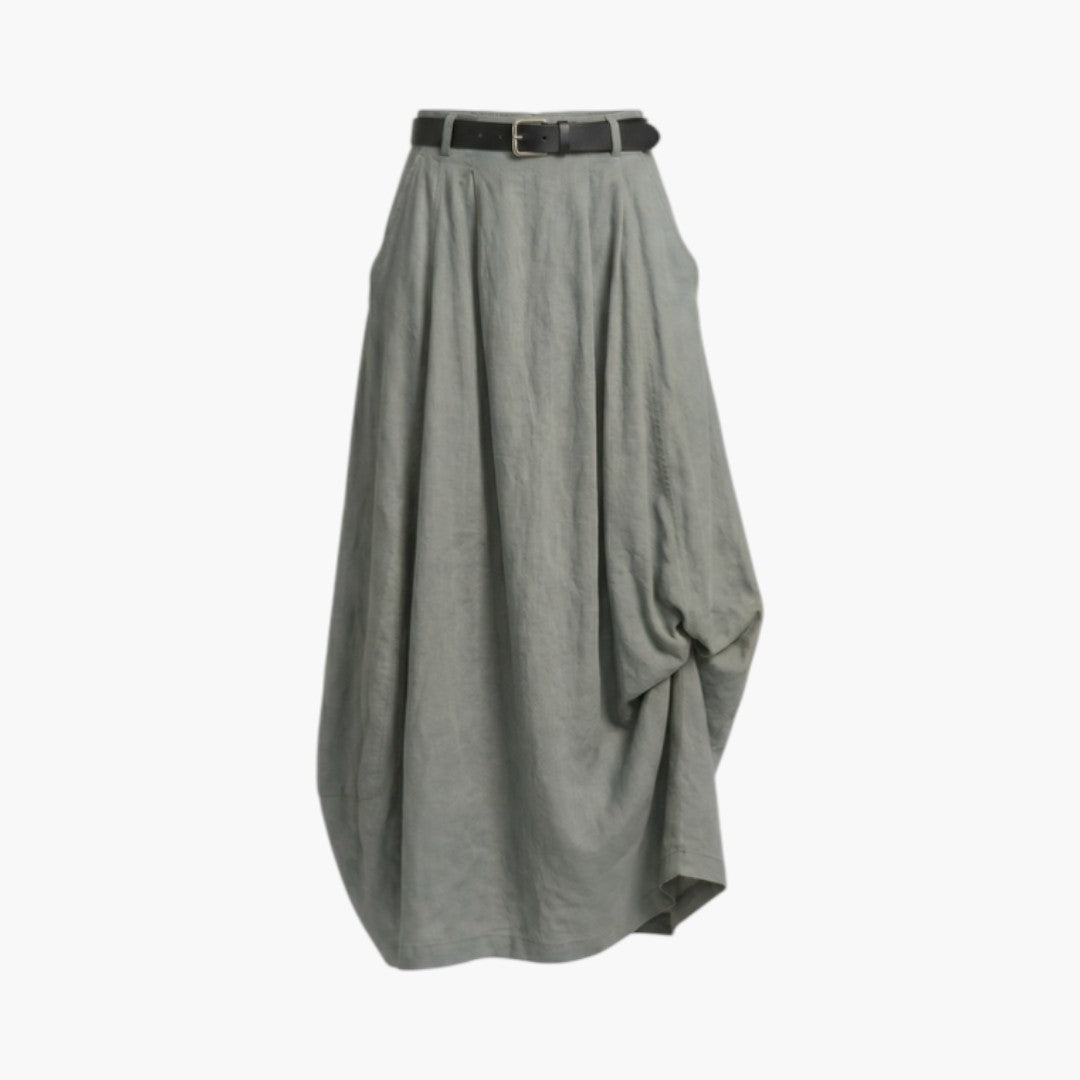 Kvinna bär elegant långkjol med bälte och fickor, visar dess bekväma passform och design.