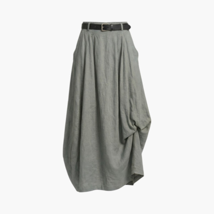 Kvinna bär elegant långkjol med bälte och fickor, visar dess bekväma passform och design.