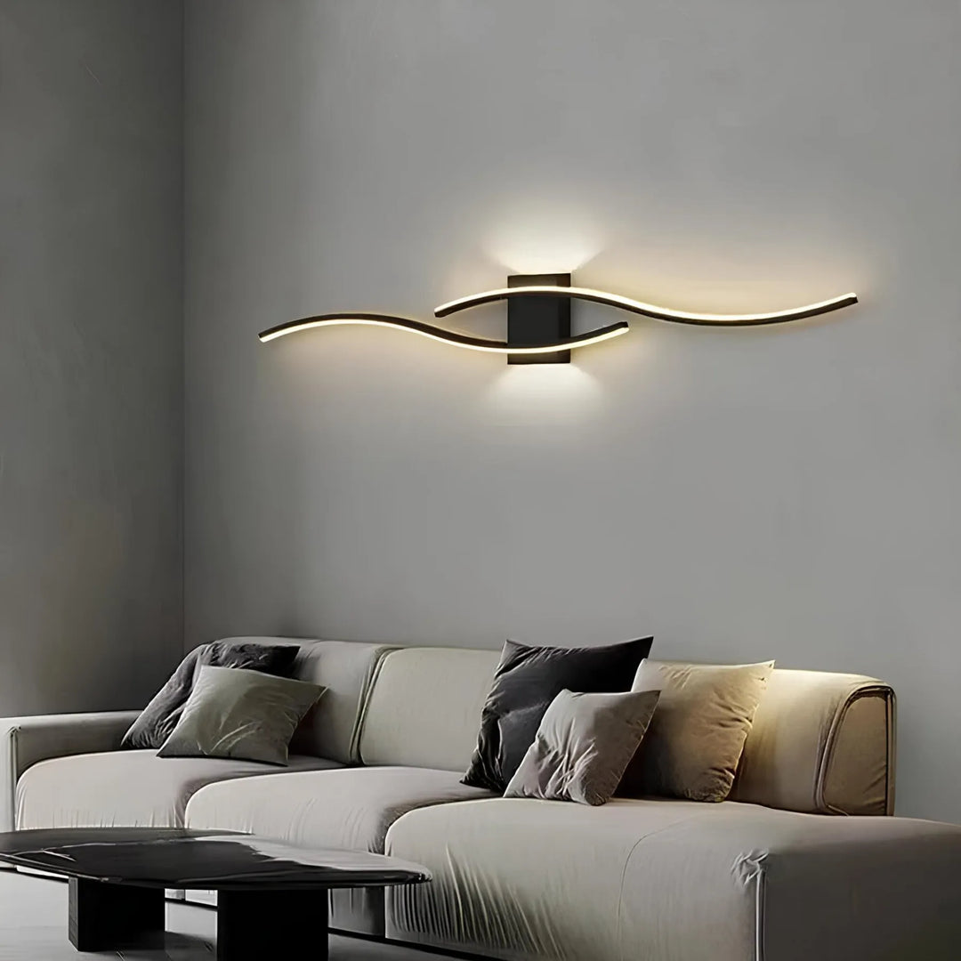 Svart linjär LED-vägglampa som ger snygg accentbelysning ovanför en soffa