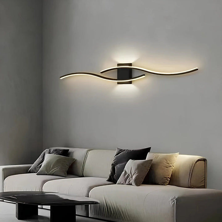Svart linjär LED-vägglampa som ger snygg accentbelysning ovanför en soffa