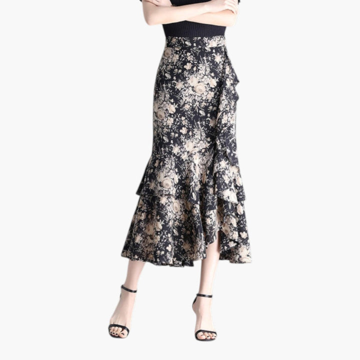 Mönstrad volangkjol med hög midja, elegant midi-längd och asymmetriska detaljer för dam.
