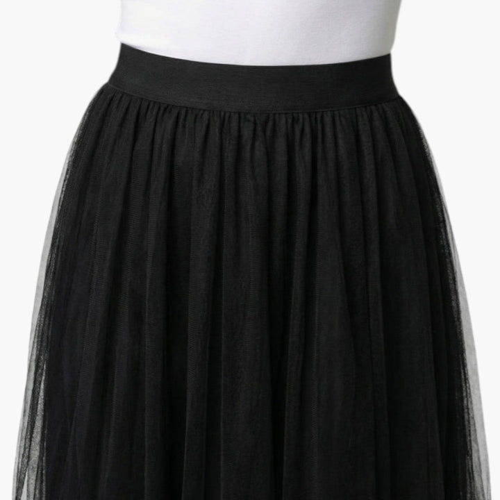 Kvinna i elegant tyllkjol, midikjol med elastisk midja. Mångsidig damkjol för fest & vardagsbruk.