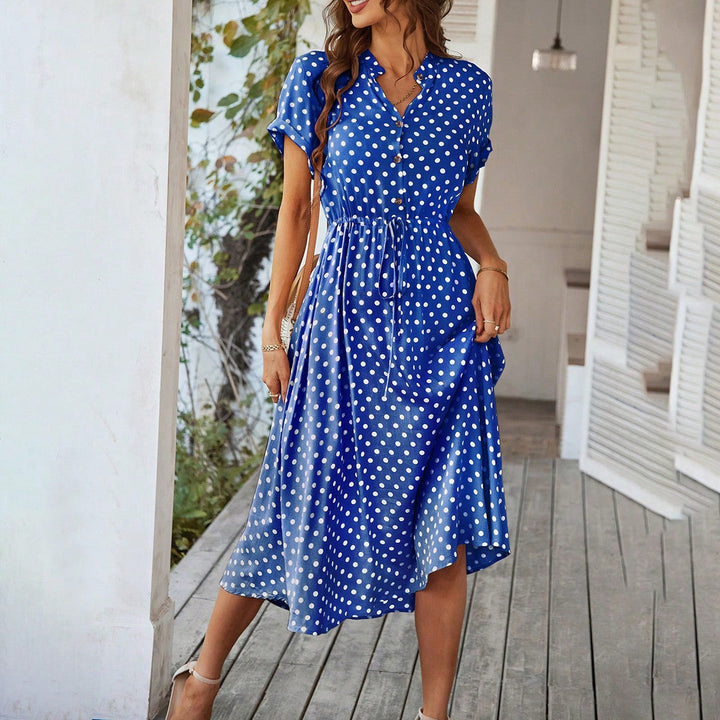Elegant sommar midi skjortklänning med små prickar. Perfekt för soliga dagar och evenemang.