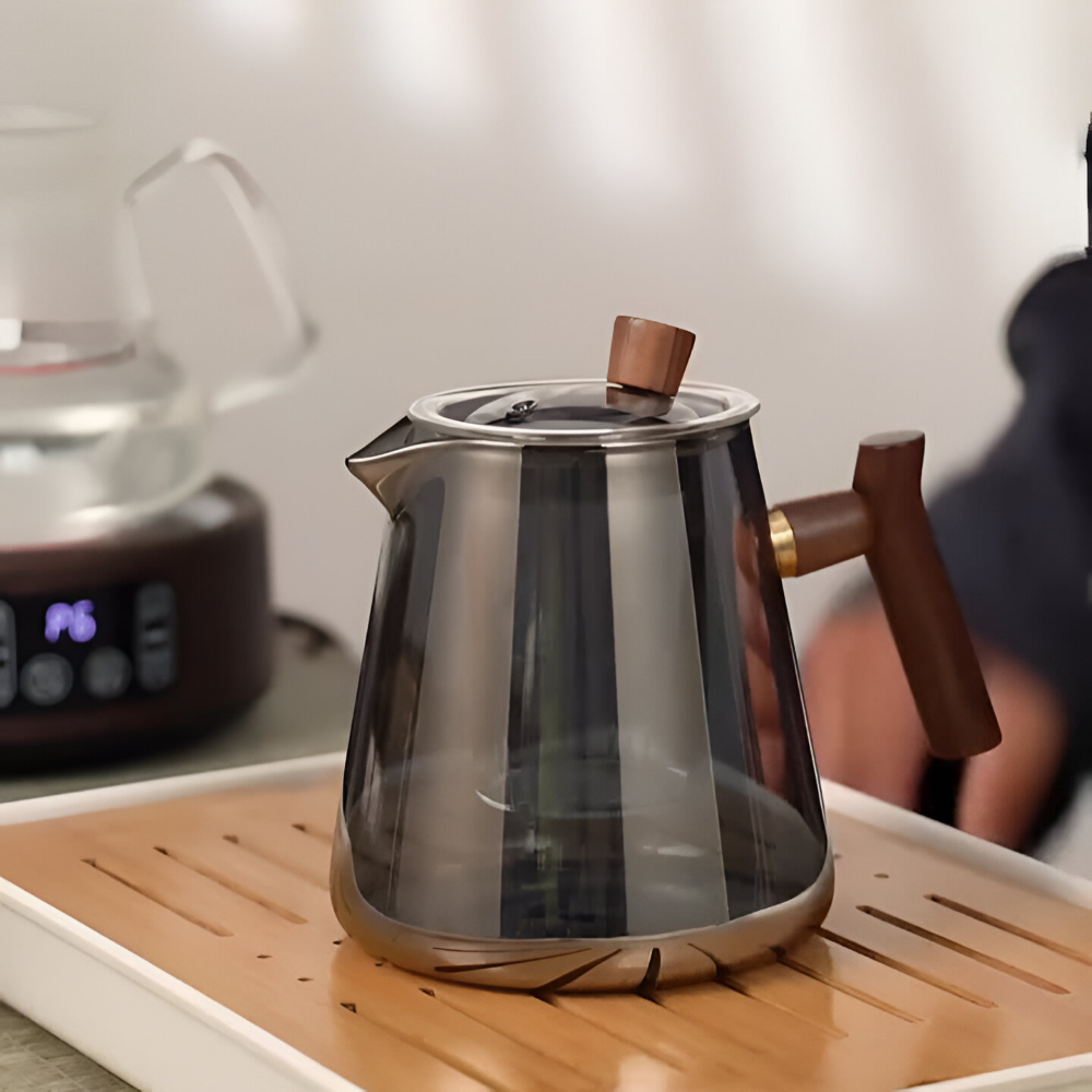 Förfinad tebryggare: elegant rökgrå tekanna med transparent design och sil för en utsökt teupplevelse.
