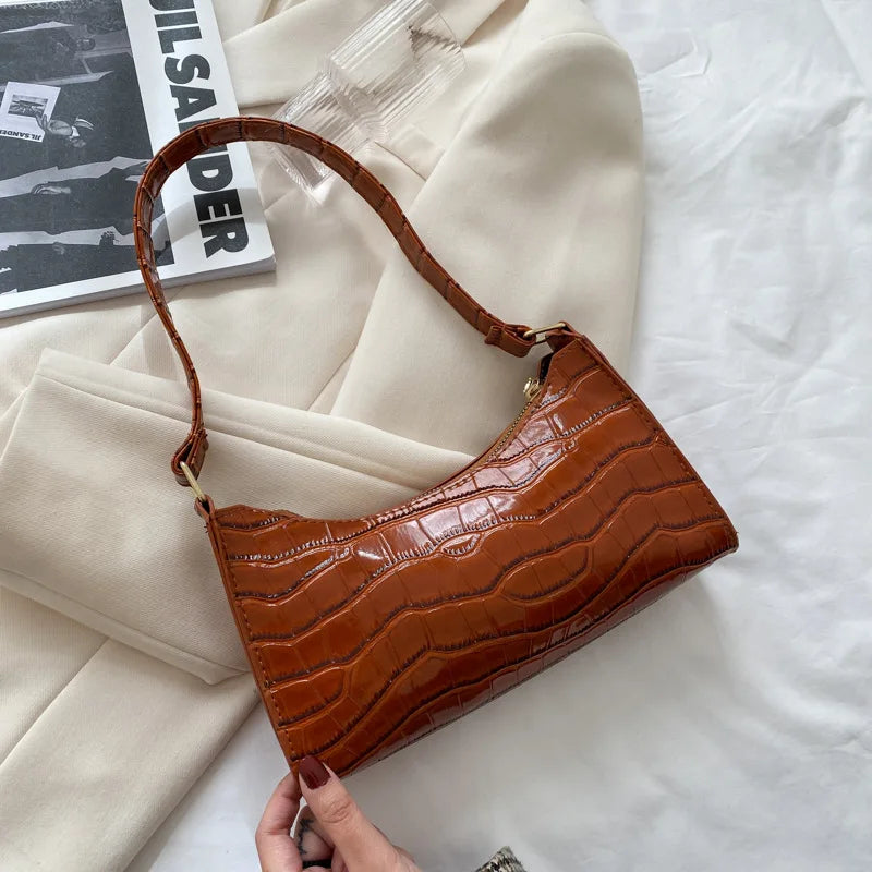 Dam bär elegant svart retro handväska med kedjedetalj.