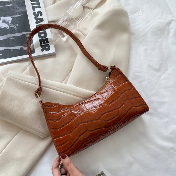 Dam bär elegant svart retro handväska med kedjedetalj.