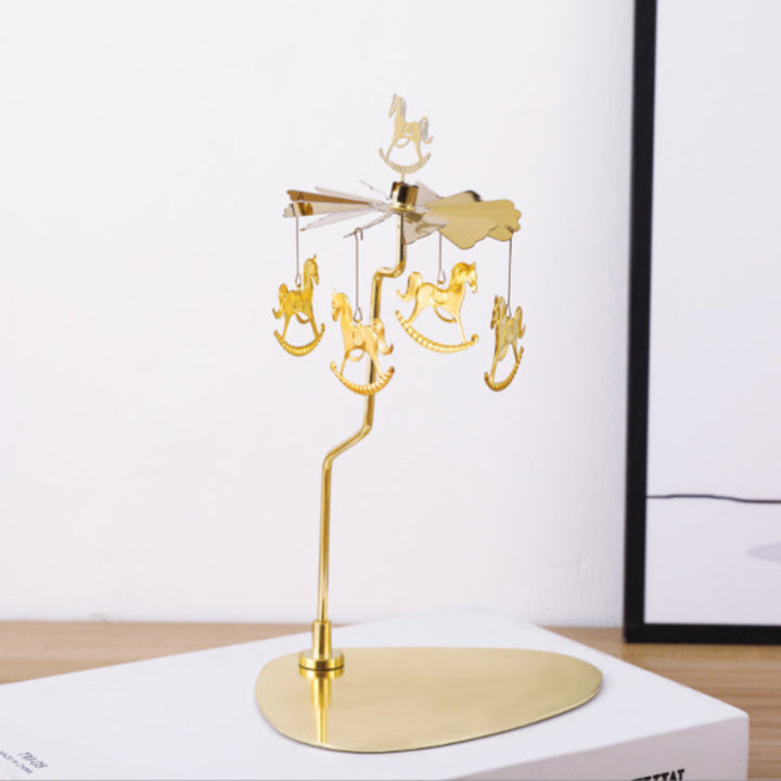 Elegant roterande ljushållare i guld, med snurrande metalliska dekorationer för heminredning, skapar magisk atmosfär.