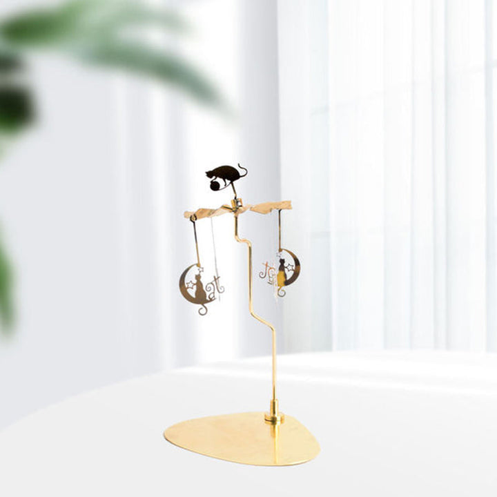 Elegant roterande ljushållare i guld, med snurrande metalliska dekorationer för heminredning, skapar magisk atmosfär.