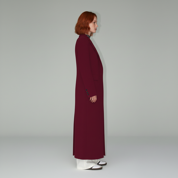 Lång figursydd damkappa i rubinrött, ett elegant och stilrent ytterplagg för alla tillfällen.