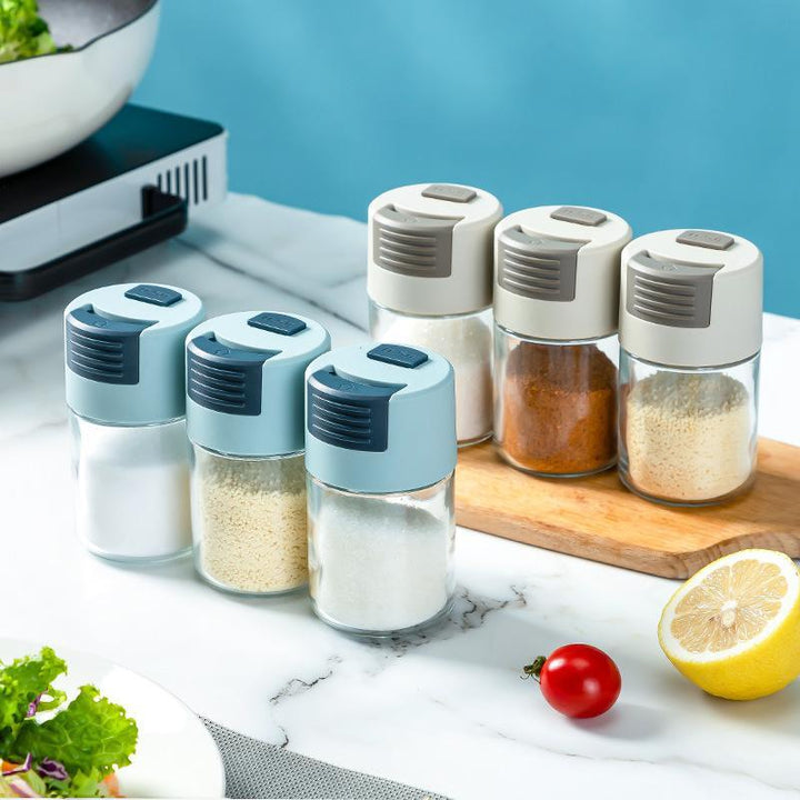 Elegant saltkärl i glas med mätfunktion, böjd form och modernt lock, perfekt för kryddförvaring i köket.