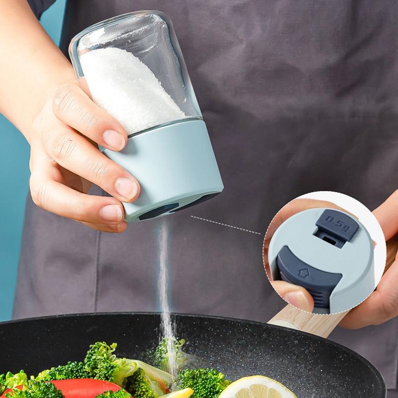 Elegant saltkärl i glas med mätfunktion, böjd form och modernt lock, perfekt för kryddförvaring i köket.