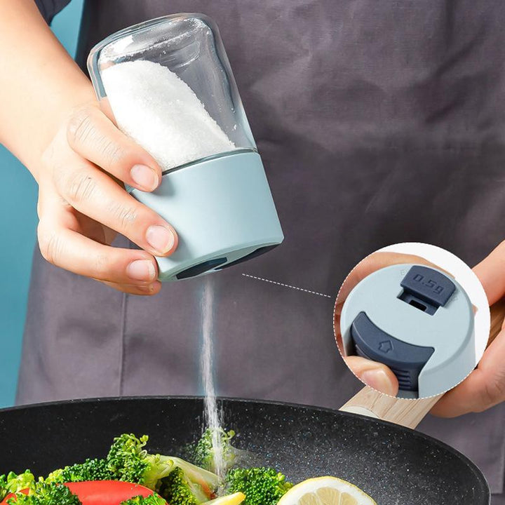 Elegant saltkärl i glas med mätfunktion, böjd form och modernt lock, perfekt för kryddförvaring i köket.