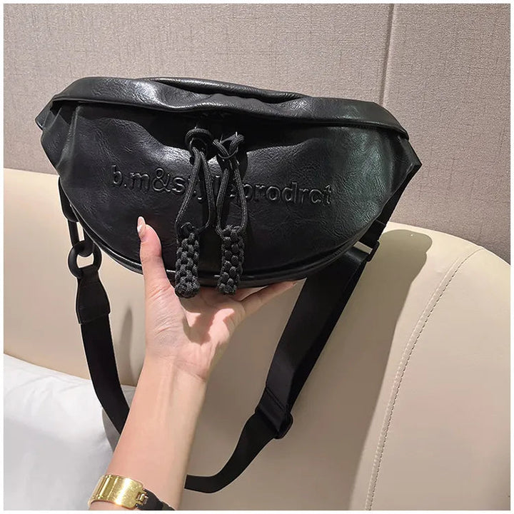 Dam bär elegant svart bröstväska crossbody. Perfekt handfri lösning för stadsbruk och resor.