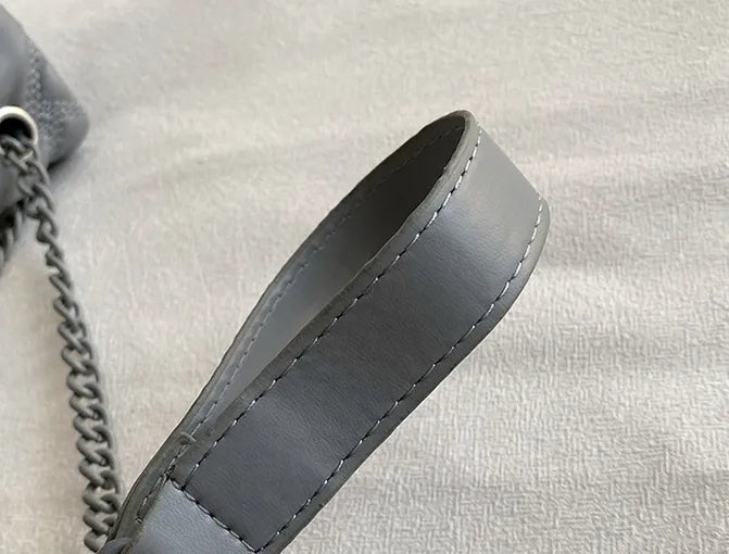 Mångsidig quiltad damväska, svart med elegant finish, kan bäras som clutch eller axelväska.