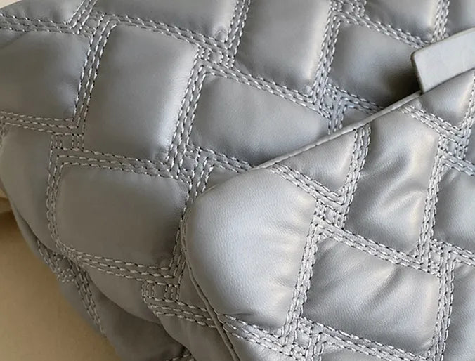 Svart quiltad damväska med justerbar rem, elegant design för en sofistikerad look.