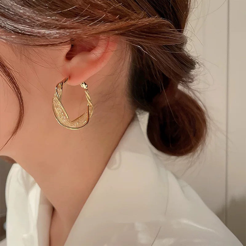 Elegant twistörhängen för kvinnor i guld och silver, geometrisk design, perfekt accessoar för alla tillfällen.