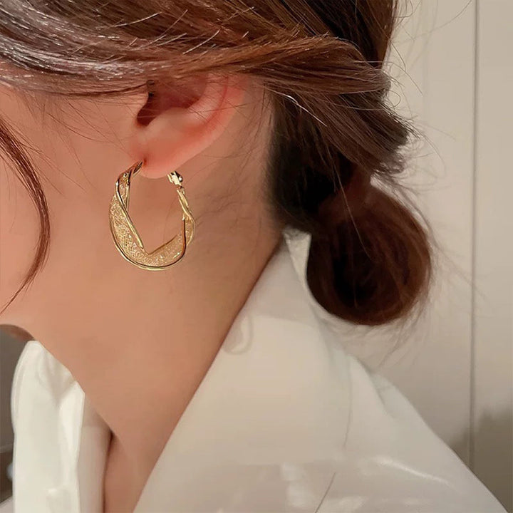 Elegant twistörhängen för kvinnor i guld och silver, geometrisk design, perfekt accessoar för alla tillfällen.