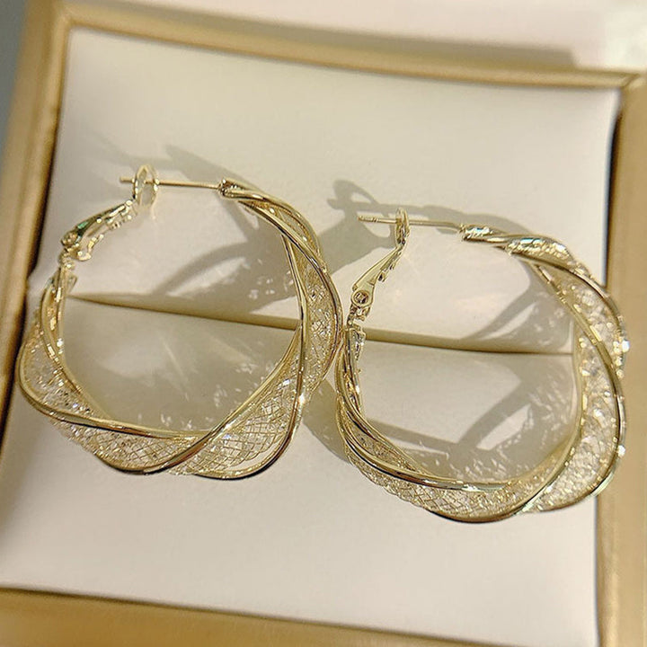 Elegant twistörhängen för kvinnor i guld och silver, geometrisk design, perfekt accessoar för alla tillfällen.
