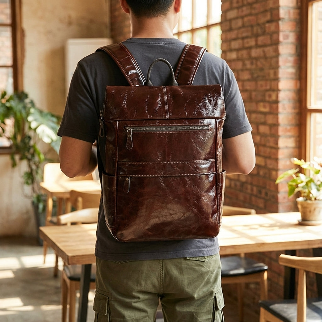 Elegant unisex läderryggsäck för laptop, svart eller brun. Praktisk arbetsväska för vardag och resa.
