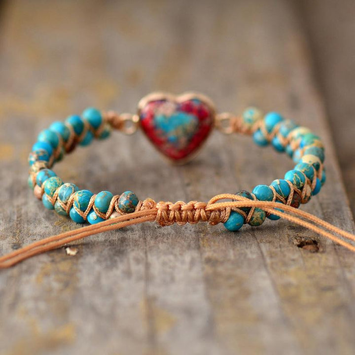 "Elegant unisex röd jaspis armband med guldpläterad legering och justerbar dragsträng."