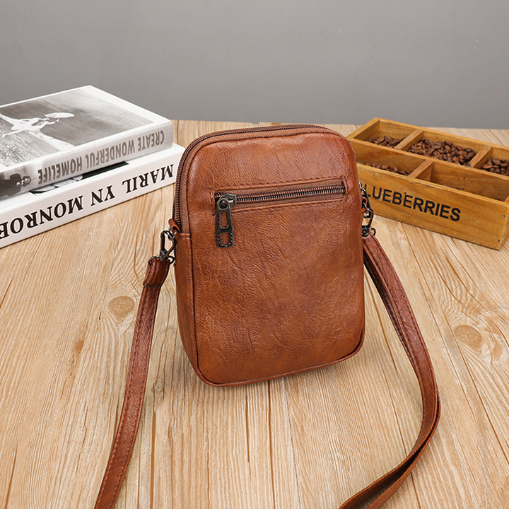 Detaljbild av vintage mini crossbody-väska med hörlursport.