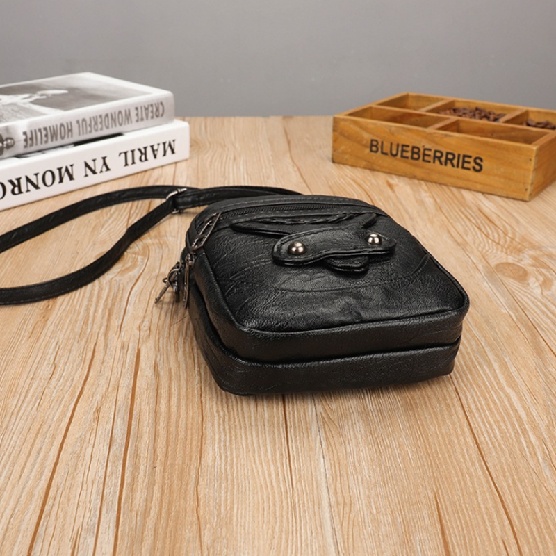 Detaljbild av vintage mini crossbody-väska med hörlursport.