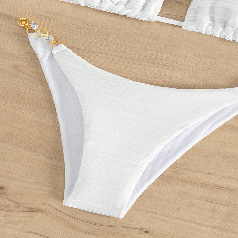 Fashionabel vit bikini med triangeltopp, smyckesdetalj och hög utskärning, sommarredo för stranden.