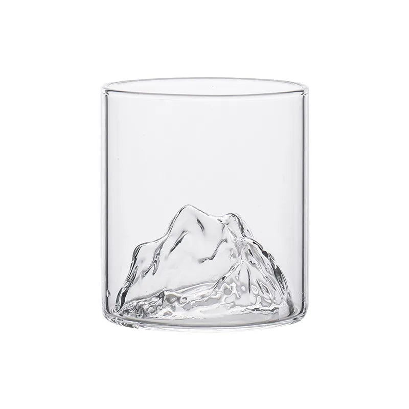 Fyllt whiskyglas på ett bord, framhävande den unika 3D bergdesignen. Ett måste för finsmakaren & designälskaren.